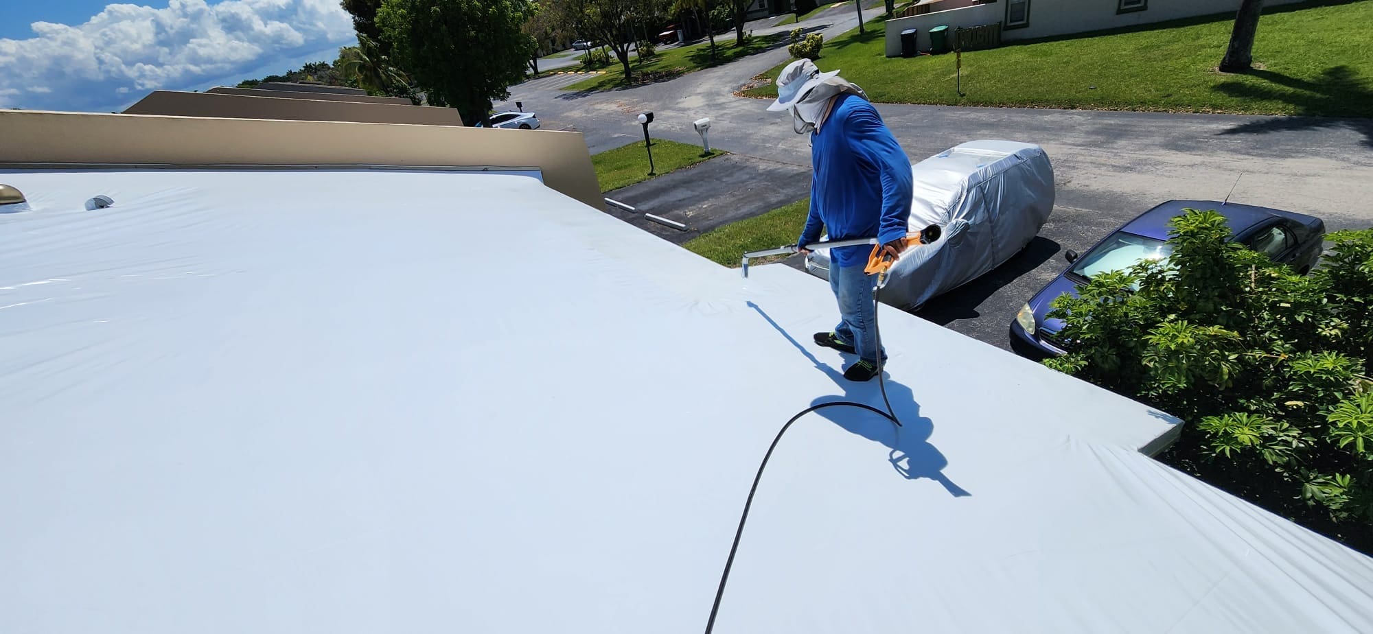 Well Mitigation Roofing Technicians sealing roof with shrink wrap.