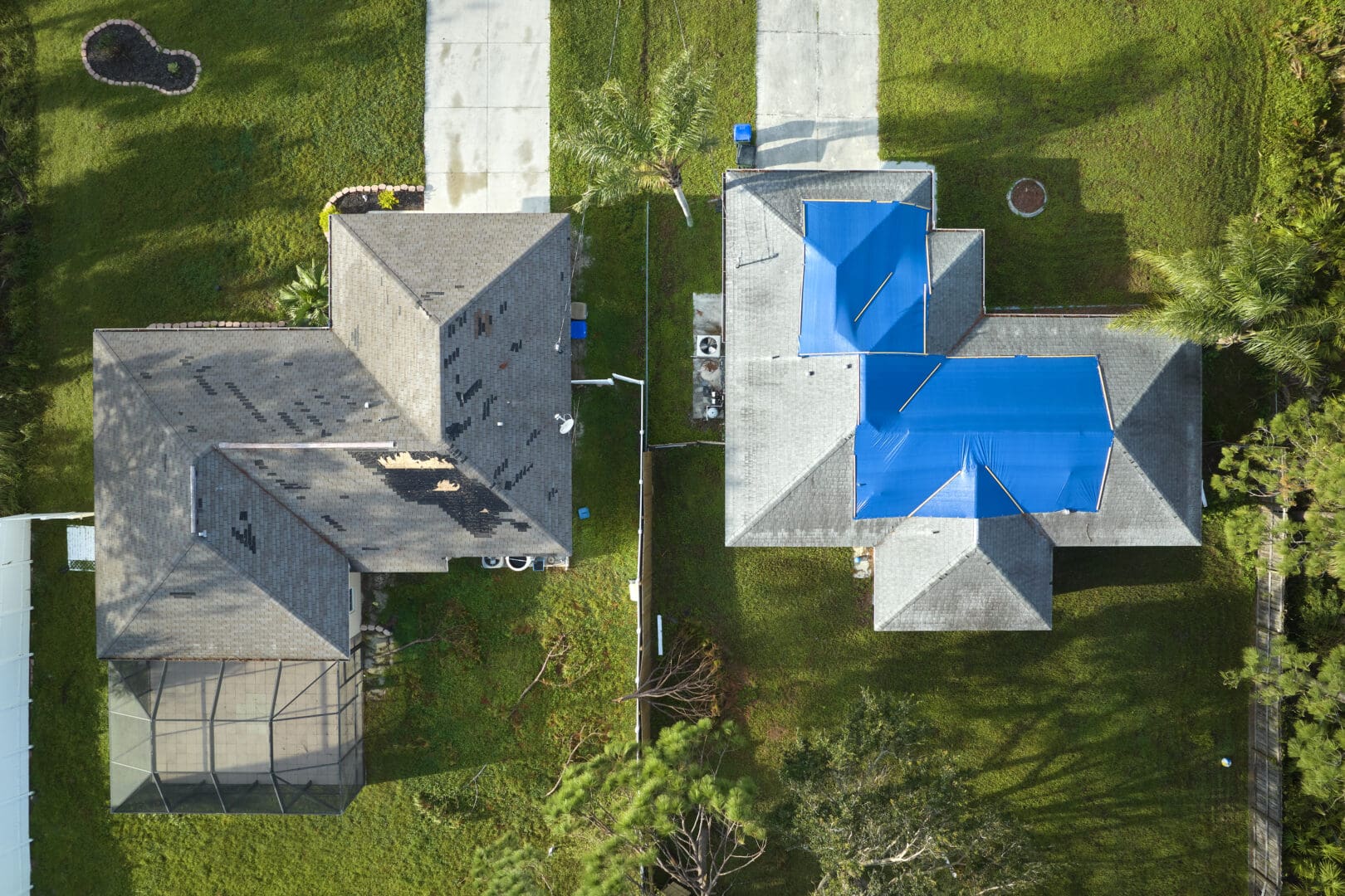 Top view of leaking house roof covered with protective tarp sheets against rain water leaks until replacement of asphalt shingles. Damage of building rooftop as aftermath of hurricane Ian in Florida.